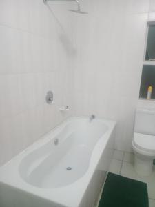 eine weiße Badewanne im Bad mit WC in der Unterkunft Good Times Cafe in Teyateyaneng + 5 Fotos