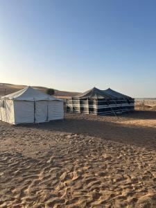 deux tentes sur le sable dans le désert dans l'établissement عزبة ابو حمزة, à Al Raka
