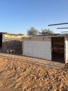 un bâtiment avec une porte au milieu d'un champ de terre dans l'établissement عزبة ابو حمزة, à Al Raka