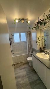 ein Badezimmer mit Waschbecken und Toilette und einem Fenster in der Unterkunft Escapade familiale à Longueuil in Longueuil