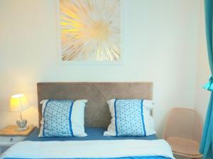 een slaapkamer met een bed met blauwe en witte kussens bij Apt au calme, 2-3 chambres, Sauna, 2 parkings, wifi in Montévrain +28 foto's