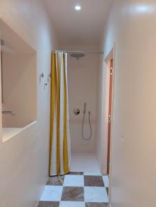 a bathroom with a shower with a yellow shower curtain at Geldmunt 37 in Ghent