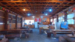 ein Raum mit Holztischen und Bänken in einem Gebäude in der Unterkunft Mountain View Cabins in Golden