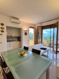 a living room with a glass table and a couch at Appartamento vista mare in Castiglioncello
