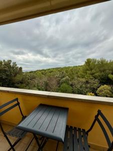 a blue bench sitting on a balcony with a view at Appartamento vista mare in Castiglioncello