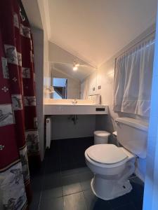a bathroom with a white toilet and a sink at Casona IslaNegra in Isla Negra +14 photos