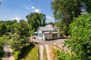 a small white house in the middle of trees at Steps to Bryson, walk anywhere downtown! in Bryson City