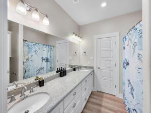 une salle de bain avec deux lavabos et un grand miroir dans l'établissement Blue Anchor, à Bolivar Peninsula 65 autres photos