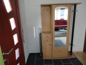 einen Holzschrank mit einem Spiegel im Wohnzimmer in der Unterkunft Jurastei14 in Wiedlisbach