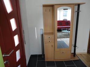 a wooden cabinet with a mirror in a living room at Jurastei14 in Wiedlisbach