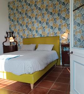 a bedroom with a bed with a yellow headboard at BotanicaSuiteTorino in Baldissero Torinese