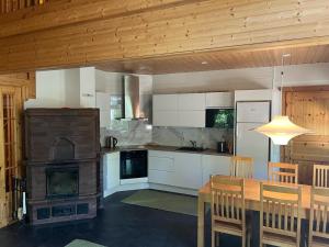 eine Küche mit Holzofen und Esstisch in der Unterkunft Holiday Home Karhu in Istunmäki