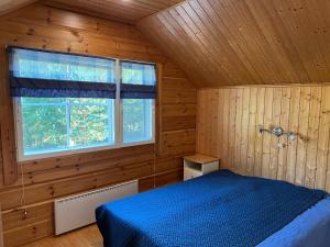 ein Schlafzimmer mit einem blauen Bett und einem Fenster in der Unterkunft Holiday Home Karhu in Istunmäki