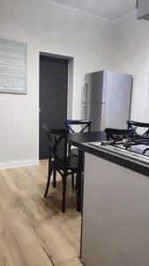 a kitchen with a table with chairs and a refrigerator at Appartement 2 chambres avec garage à strasbourg in Strasbourg