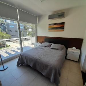 a bedroom with a bed and a large window at Manzana 1 in Mar de las Pampas +22 photos
