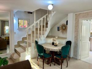 a dining room with a table and chairs and a staircase at Ines House in La Marsa