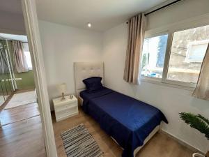 a small bedroom with a bed and a window at Ines House in La Marsa
