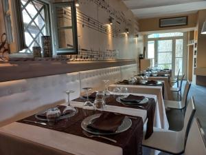a row of tables in a restaurant with glasses on them at B&B Locanda Toscanini in Cetona