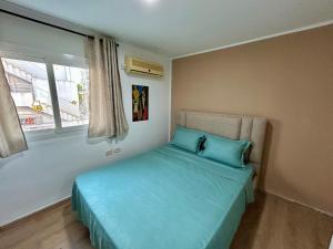 a bedroom with a blue bed with a window at Ines House in La Marsa +8 photos