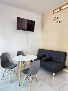 a living room with a couch and a table and chairs at Casa Elbatros in Manzanillo +5 photos