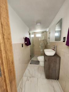 a bathroom with a sink and a toilet at Casa Elbatros in Manzanillo