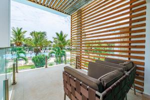a balcony with a couch and a view of palm trees at Tamala Beach Resort in Kotu