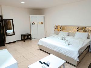 Un dormitorio con una gran cama blanca y dos mesas. en Siveen Hotel, en Amán