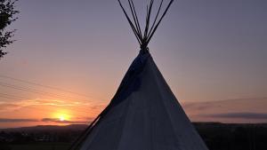 a close up of a tent with the sunset in the background at Stone Circle Glamping in Durrington