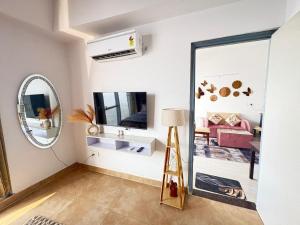 a living room with a mirror and a pink couch at 1bhk Apartment With Swimming Sector 75 Noida in Noida