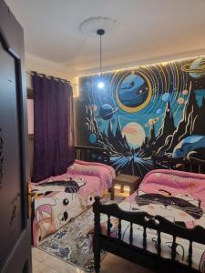 a room with two beds and a mural on the wall at Taher's Hostel in Cairo