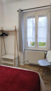 een slaapkamer met een bed en een stoel en 2 ramen bij Strasbourg - Deux Chambres & Garage in Straatsburg +16 foto's