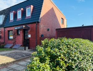 Gardenholm im Süden von Westerland في فيسترلاند: منزل من الطوب الأحمر على سقف أسود