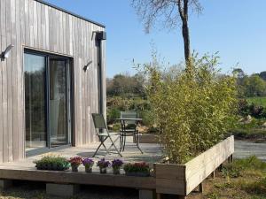 a house with a table and chairs on a patio at Studio neuf dans un espace boisé in Locronan +6 photos