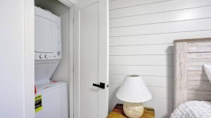 ein weißes Zimmer mit einer Lampe neben einer Tür in der Unterkunft Karmen's Lake Cottage A1 in SeaTac