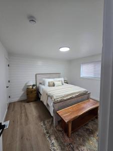 ein Schlafzimmer mit einem Bett und einem Holztisch in der Unterkunft Karmen's Lake Cottage A1 in SeaTac