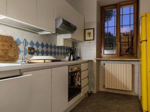 a kitchen with white cabinets and a yellow refrigerator at BotanicaSuiteTorino in Baldissero Torinese