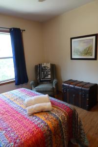 a bedroom with a bed and a chair and a window at Legacy Lakehouse in Spicer +2 photos