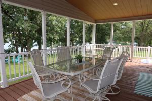 a glass table and chairs on a porch at Legacy Lakehouse in Spicer