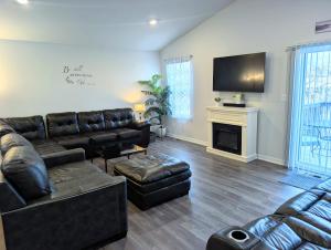 a living room with a leather couch and a fireplace at Modern Comfort in Des Moines
