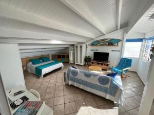 a bedroom with two beds and a living room at Loft Sofi in Morro del Jable