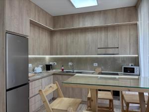 a kitchen with a table with chairs and a refrigerator at Kilometer 0 Comfortable Apartment in Shkodër