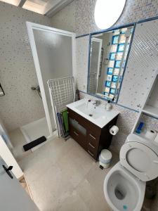 a bathroom with a toilet and a sink and a mirror at Loft Sofi in Morro del Jable +20 photos