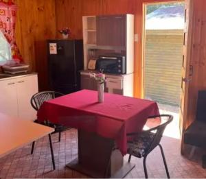 Una mesa roja en una cocina con un mantel rojo. en Refugio Vilches, en Vilches