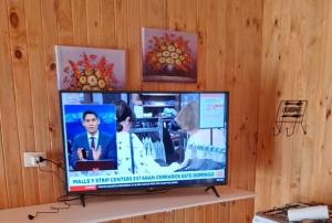 TV de pantalla plana en una pared de madera en Refugio Vilches, en Vilches