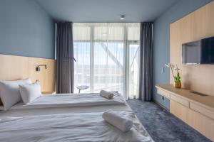 um quarto com uma cama grande e uma televisão em Hotel Princeps em Sátoraljaújhely mais 75 fotografias