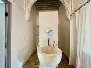 Suite John Pawson Dar Kiki Medina, Tunis في تونس: حمام مع حوض حجري كبير في الغرفة +35 صورة