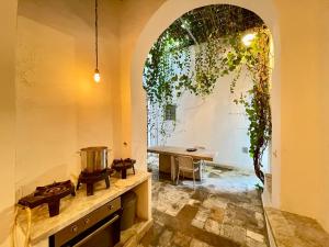 Suite John Pawson Dar Kiki Medina, Tunis في تونس: مطبخ مع موقد وطاولة في الغرفة