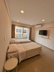 two beds in a room with a tv and a bed sidx sidx sidx at Otero Coliving - Studio Entero U8 in San Salvador de Jujuy +6 photos
