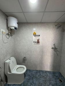 a bathroom with a white toilet and a sink at 1bhk Apartment With Swimming Sector 75 Noida in Noida +3 photos