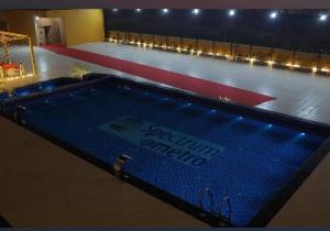 an empty swimming pool in a gym with lights at Spectrum Metro Mall 1bhk With Swimming Apartment Sector 75 Noida in Noida